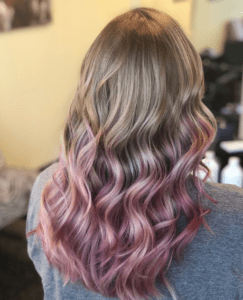 Gradient colored from blonde to pink wavy hair
