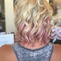 Woman with short blonde curly hair with pink endings