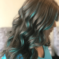 Girl with brown wavy hair with blue colored stripes