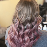 Gradient colored from blonde to pink wavy hair